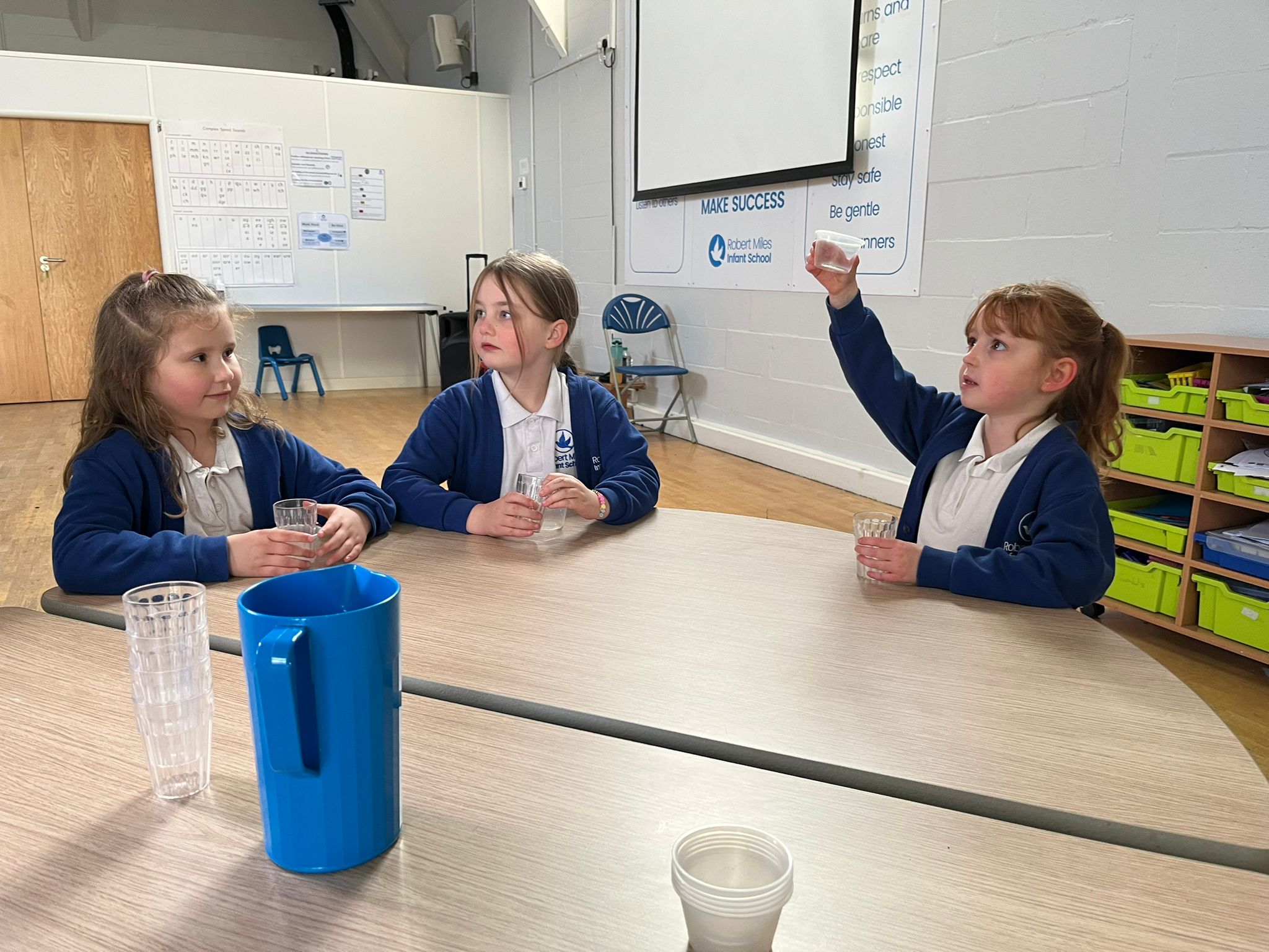 Erin Withers (right), a year two pupil demonstrating how the school have switched to single-use plastic.
